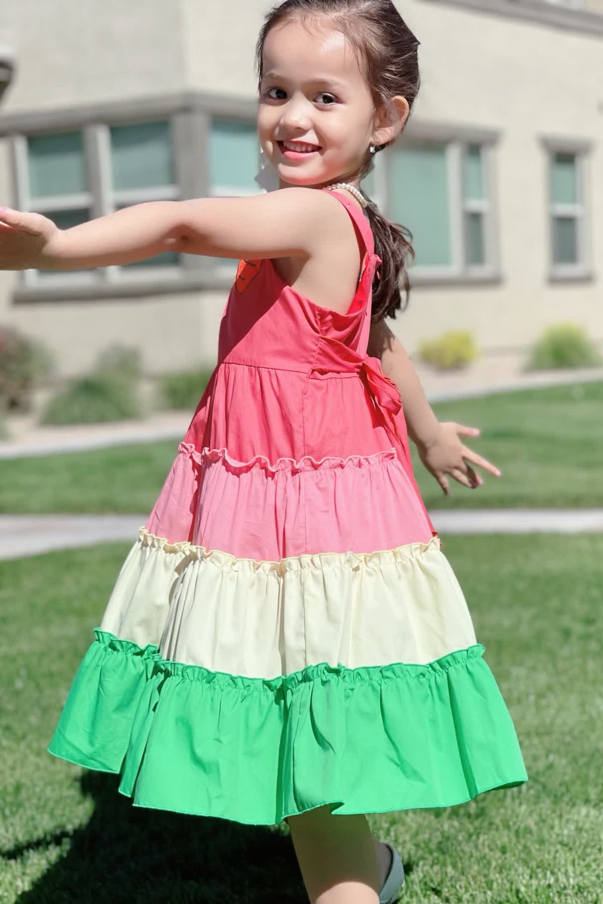 Bunny Carrot dress — little girl in coral, cream, and green tiered dress